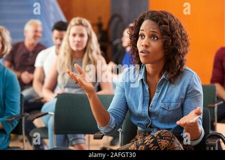 Frustrierte Frau Fragen Stellen in der Nachbarschaft Treffen im Gemeindezentrum Stockfoto