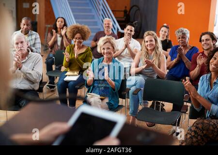 Gruppe die Teilnahme an Nachbarschaft Treffen applaudieren Lautsprecher im Community Center Stockfoto