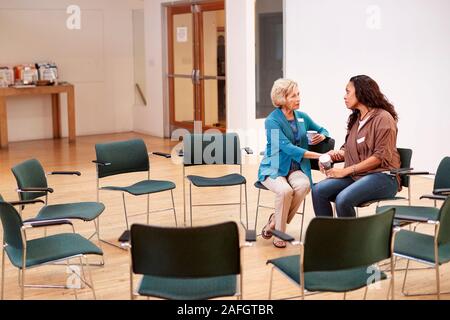 Zwei Frauen sprechen, nachdem Treffen im Gemeindezentrum Stockfoto
