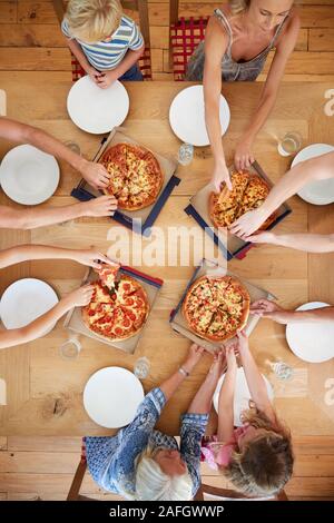 Ansicht von oben von Multi-Generation Familie sitzt um den Tisch essen Pizza zusammen Stockfoto