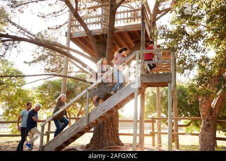 Multi-Generation Familie Klettern Outdoor Holz- Plattform zu Tree House im Garten Stockfoto