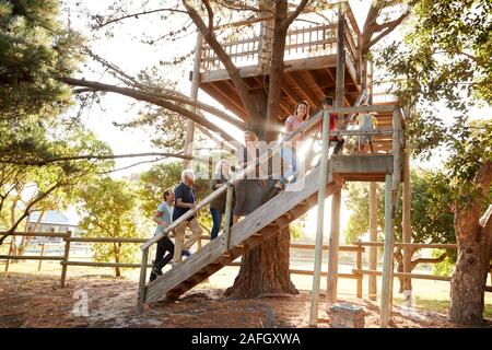 Multi-Generation Familie Klettern Outdoor Holz- Plattform zu Tree House im Garten Stockfoto