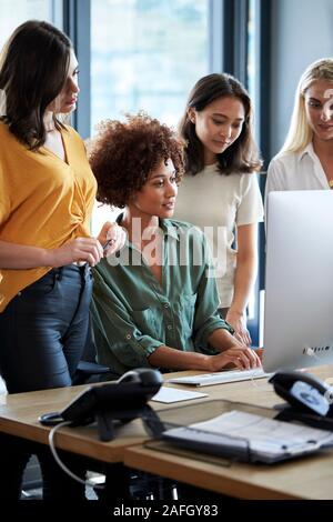 Vier weibliche creatives Arbeiten am PC-Monitor in einem Büro, Seitenansicht, Vertikal, Nahaufnahme Stockfoto