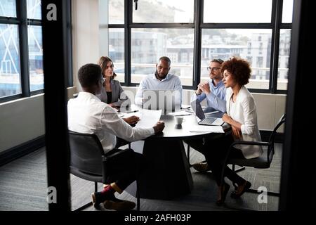 Corporate Business Kollegen im Gespräch in einem Besprechungsraum, vom Eingang gesehen Stockfoto
