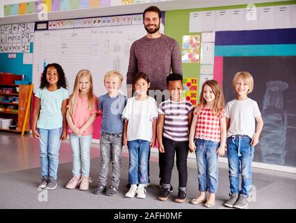 Portrait von Grundschülern im Klassenzimmer mit männlichen Lehrer Ständigen Stockfoto