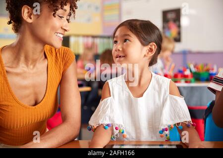 Grundschullehrer und weibliche Schüler Zeichnung mit digitalen Tablette im Klassenzimmer Stockfoto