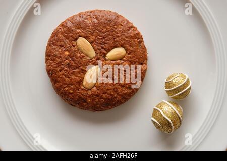 Noch immer leben mit einem leckeren braunen Elisengingerbreads mit Mandeln und weihnachtliche Dekoration liegen auf einem reinen weißen Porzellanteller Stockfoto