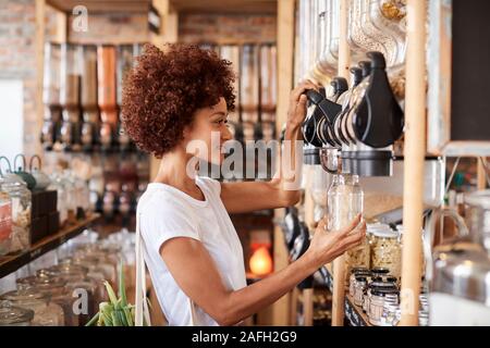 Frau, die den Kauf von Getreide und Körner In nachhaltige Kunststoff sich Lebensmittelgeschäft Stockfoto