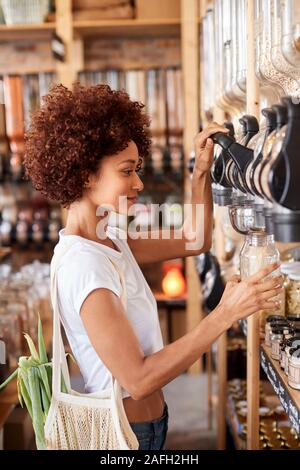 Frau, die den Kauf von Getreide und Körner In nachhaltige Kunststoff sich Lebensmittelgeschäft Stockfoto