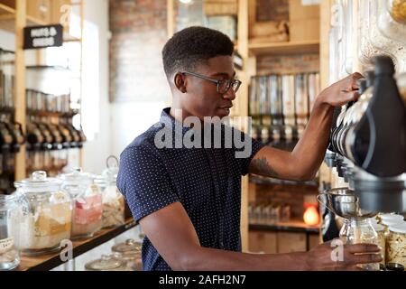 Mann Kaufen Getreide und Körner In nachhaltige Kunststoff sich Lebensmittelgeschäft Stockfoto