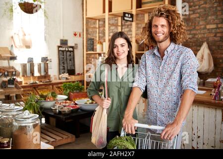Portrait von Paar mit Trolley Kaufen Frisches Obst und Gemüse in Kunststoff sich Lebensmittelgeschäft Stockfoto