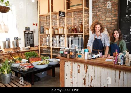 Portrait von Männlichen und Weiblichen Besitzer der Nachhaltigen Kunststoff Free Grocery Store hinter Sales Desk Stockfoto