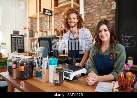 Portrait von Männlichen und Weiblichen Besitzer der Nachhaltigen Kunststoff Free Grocery Store hinter Sales Desk Stockfoto