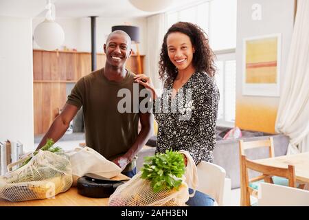 Portrait von Paar Heimweg von Shopping Trip Auspacken Kunststoff Kostenlose Einkaufstaschen Stockfoto