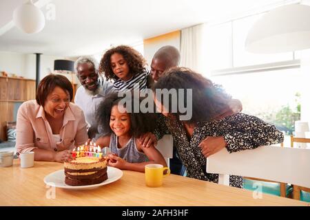 Multi-Generation Familie feiern Enkelinnen Geburtstag zu Hause mit Kuchen und Kerzen Stockfoto