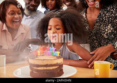 Multi-Generation Familie feiern Enkelinnen Geburtstag zu Hause mit Kuchen und Kerzen Stockfoto