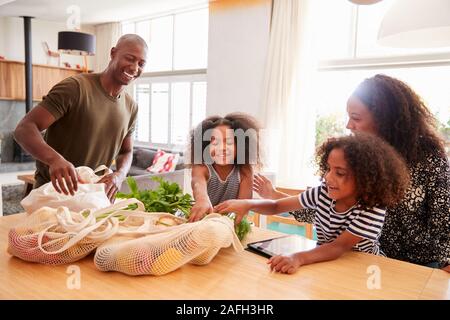 Familie Heimweg von Shopping Trip Auspacken Kunststoff Kostenlose Einkaufstaschen Stockfoto