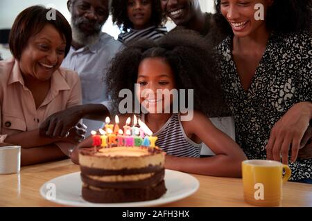 Multi-Generation Familie feiern Enkelinnen Geburtstag zu Hause mit Kuchen und Kerzen Stockfoto