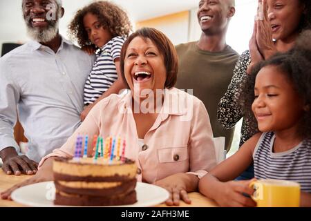 Omas Geburtstag multi-generation Familie feiern zu Hause mit Kuchen und Kerzen Stockfoto