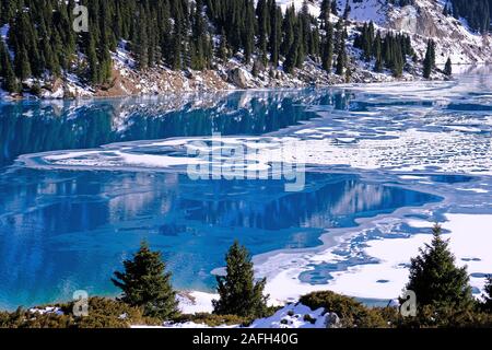 Herbst gibt Weg für Winter, Lufttemperatur sinkt und das Wasser in den See beginnt zu frieren. Textur und Muster von Eis auf dem ruhigen Wasser Oberfläche Stockfoto