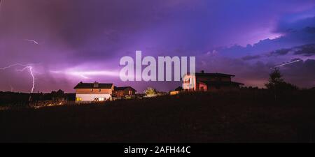 Tal mit Häusern im Grünen unter einem bewölkten Himmel bedeckt Während eines Sturms Stockfoto