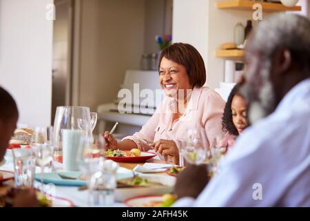 Multi-Generation Familie sitzt um den Tisch zu Hause genießen Mahlzeit zusammen Stockfoto