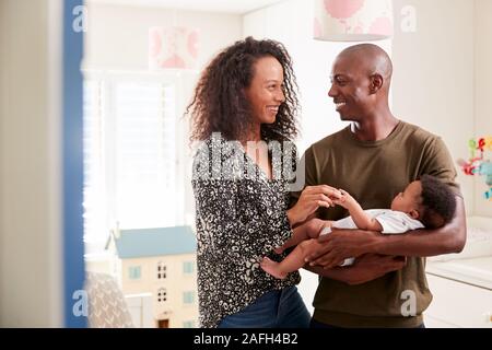 Liebevolle Eltern im Kindergarten Kuscheln Baby Sohn zu Hause stehend Stockfoto