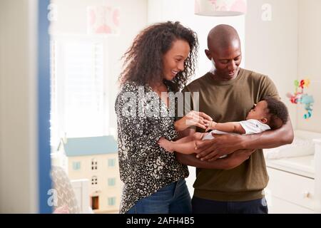 Liebevolle Eltern im Kindergarten Kuscheln Baby Sohn zu Hause stehend Stockfoto