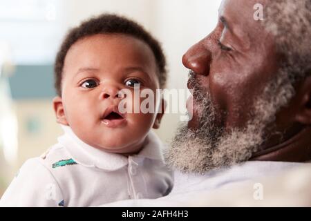 Stolze Großvater Kuscheln Baby Enkel in Kindergärten zu Hause Stockfoto