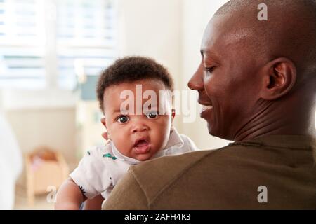 Stolzer Vater streicheln Baby Sohn im Kindergarten zu Hause Stockfoto