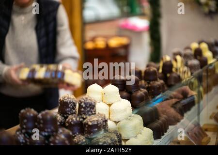 Horizontale selektiven Fokus auf Markt Anbieter verkaufen Dutzende von köstlichen Schokolade Küsse und Süßwaren Abschaltdruck Stockfoto