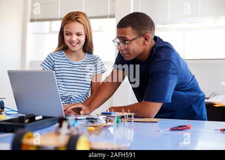 Studentin mit Lehrer Gebäude Roboter Fahrzeug nach der Schule Computer Coding Klasse Stockfoto