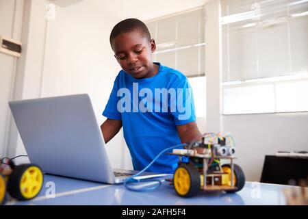 Männliche Schüler Bauen und Programmieren Roboter Fahrzeug nach der Schule Computer Coding Klasse Stockfoto