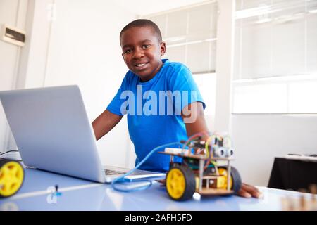 Portrait der männlichen Schüler Bauen und Programmieren Roboter Fahrzeug in der Schule Computer Coding Klasse Stockfoto