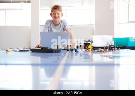 Portrait der männlichen Schüler Bauen und Programmieren Roboter Fahrzeug in der Schule Computer Coding Klasse Stockfoto