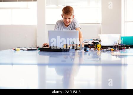 Männliche Schüler Bauen und Programmieren Roboter Fahrzeug in der Schule Computer Coding Klasse Stockfoto