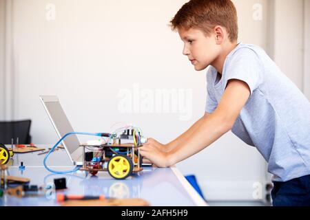 Männliche Schüler Bauen und Programmieren Roboter Fahrzeug in der Schule Computer Coding Klasse Stockfoto