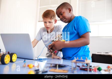 Zwei männliche Schüler Bauen und Programmieren Roboter Fahrzeug nach der Schule Computer Coding Klasse Stockfoto