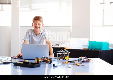 Portrait der männlichen Schüler Bauen und Programmieren Roboter Fahrzeug in der Schule Computer Coding Klasse Stockfoto