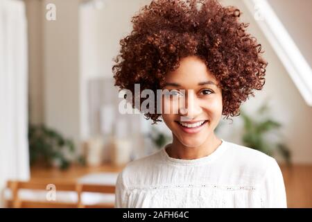 Portrait von Lächelnden jungen Frau in Loft Apartment Stockfoto