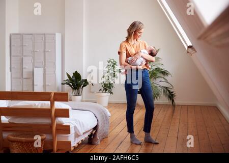 Liebevolle Mutter, neugeborenes Baby zu Hause in Loft Apartment Stockfoto