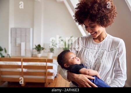 Liebevolle Mutter, neugeborenes Baby zu Hause in Loft Apartment Stockfoto