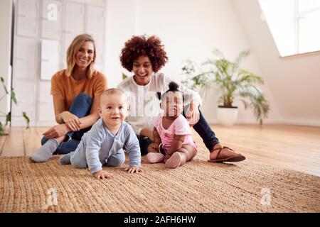 Porträt von zwei Mütter treffen für Spielen mit Babys zu Hause in Loft Apartment Stockfoto