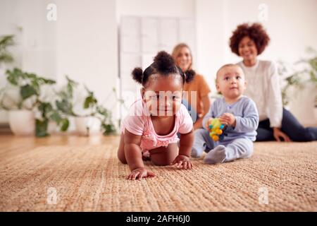 Zwei Mütter treffen für Spielen mit Babys zu Hause in Loft Apartment Stockfoto