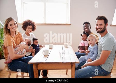 Porträt von zwei Familien mit Babys Treffen um Tabelle auf Play Datum zu Hause Stockfoto