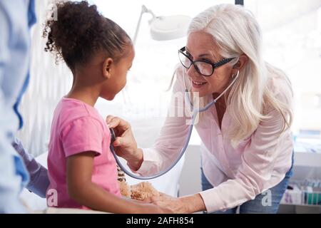 Vater mit Tochter in Absprache mit Arzt im Büro Stockfoto