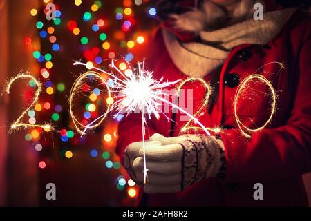 Frau mit bengalischen Lichter über bokeh Hintergrund. Weihnachten Konzept. Stockfoto