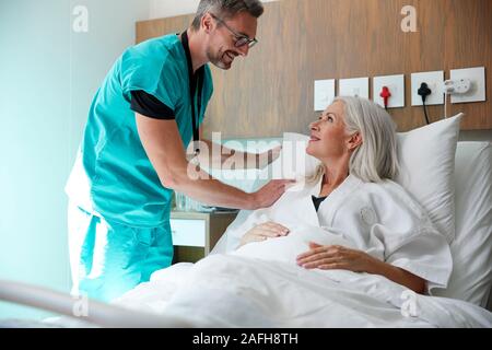 Chirurg besuchen und das Gespräch mit Reife Weibliche Patienten im Krankenhaus Bed Stockfoto