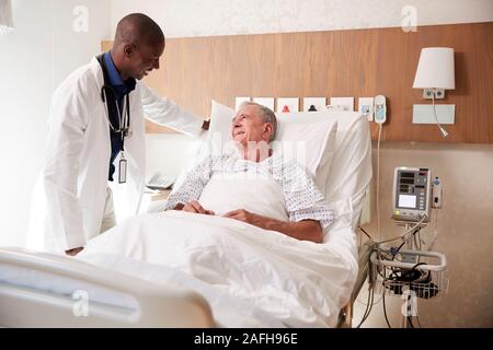 Arzt besuchen und das Gespräch mit älteren männlichen Patienten im Krankenhaus Bed Stockfoto