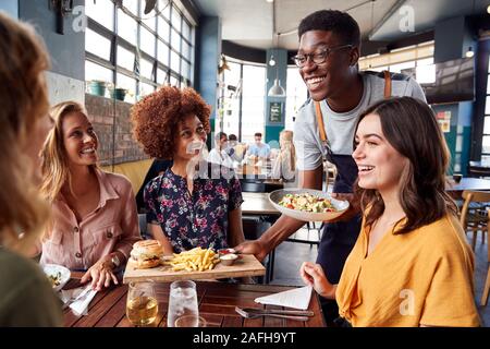 Kellner, die Gruppe der weiblichen Freunde treffen für Getränke und Essen im Restaurant Stockfoto